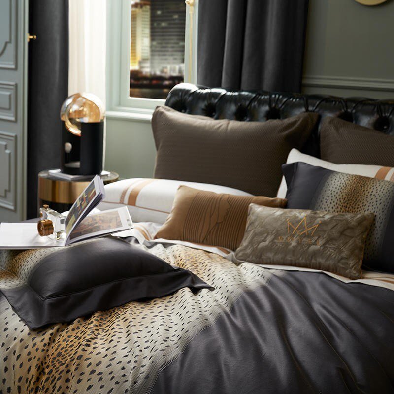 Luxurious bedding set with leopard print accents, layered with a mix of decorative pillows in neutral tones and metallic finishes. A modern side table with a glass lamp complements the sophisticated, dark-themed bedroom decor.