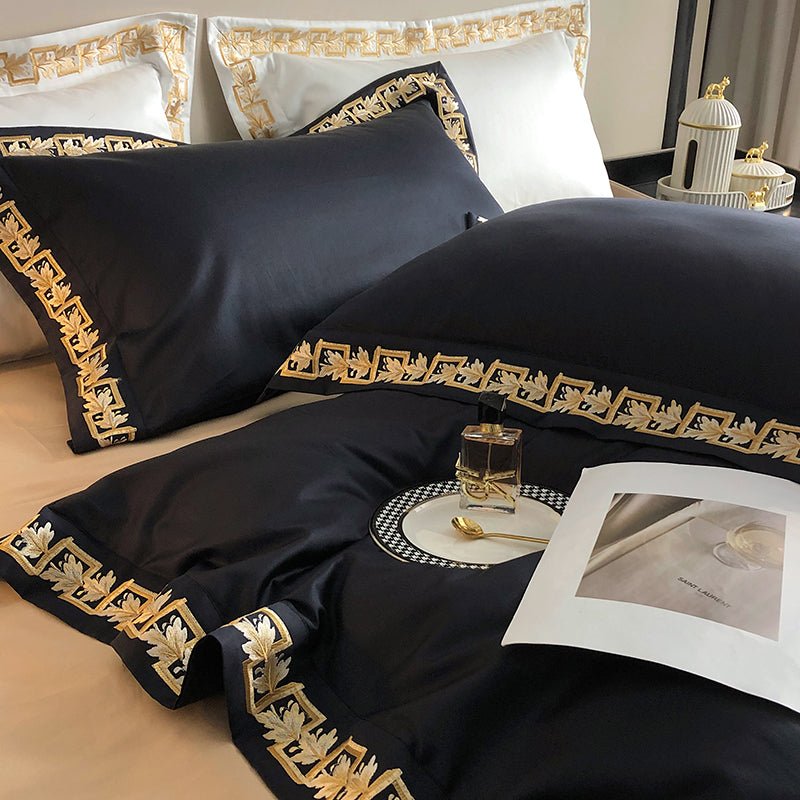 A closer view of the black Egyptian cotton bedding set, showcasing the detailed gold embroidery on the pillowcases and duvet cover, paired with elegant white pillow accents featuring complementary gold trim.