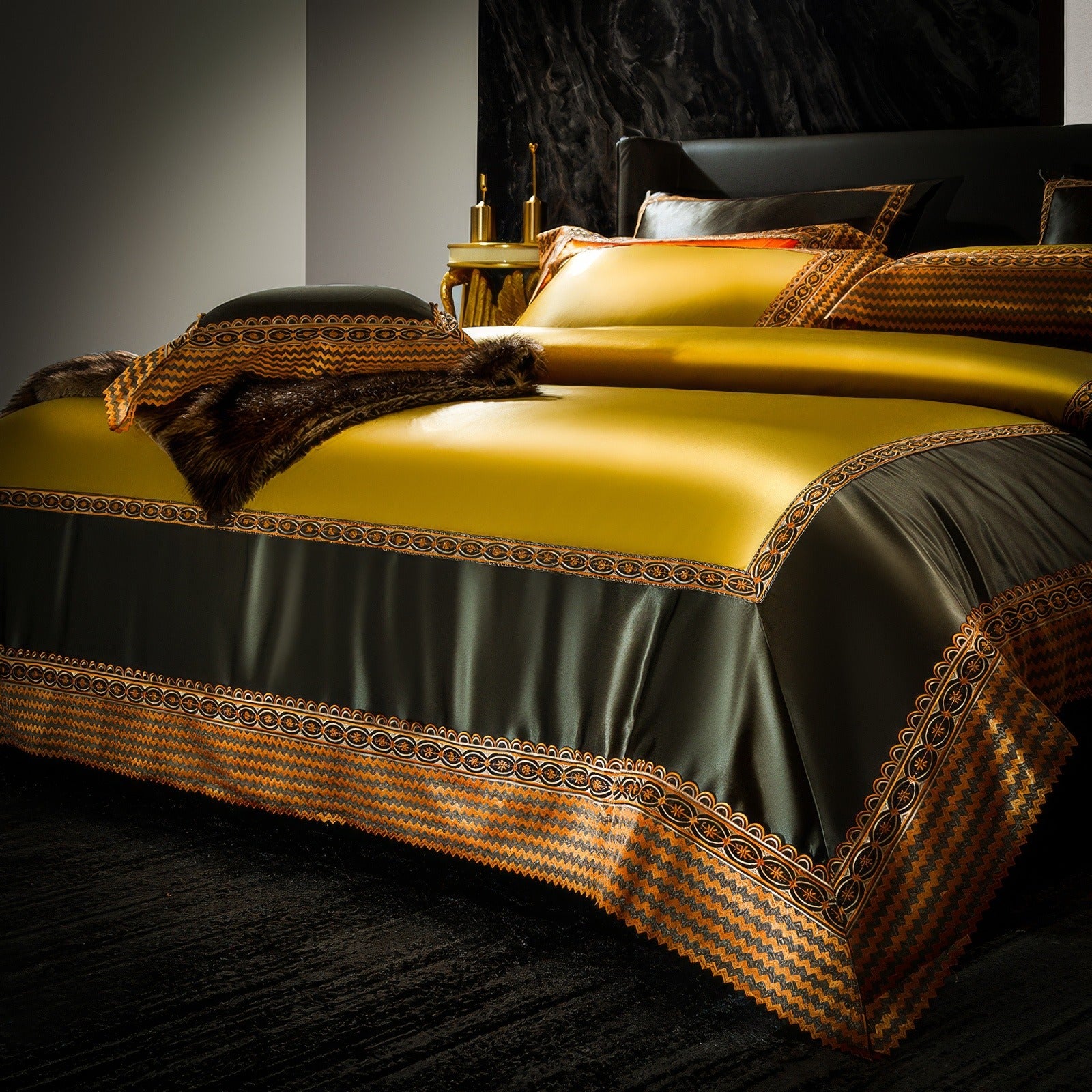 A close-up of a luxurious bed featuring yellow and dark green satin bedding with intricate gold borders. The bed is accented with a rich fur throw draped over the corner, adding a touch of opulence. The decorative trim on the duvet and pillowcases enhances the elegant and regal aesthetic.