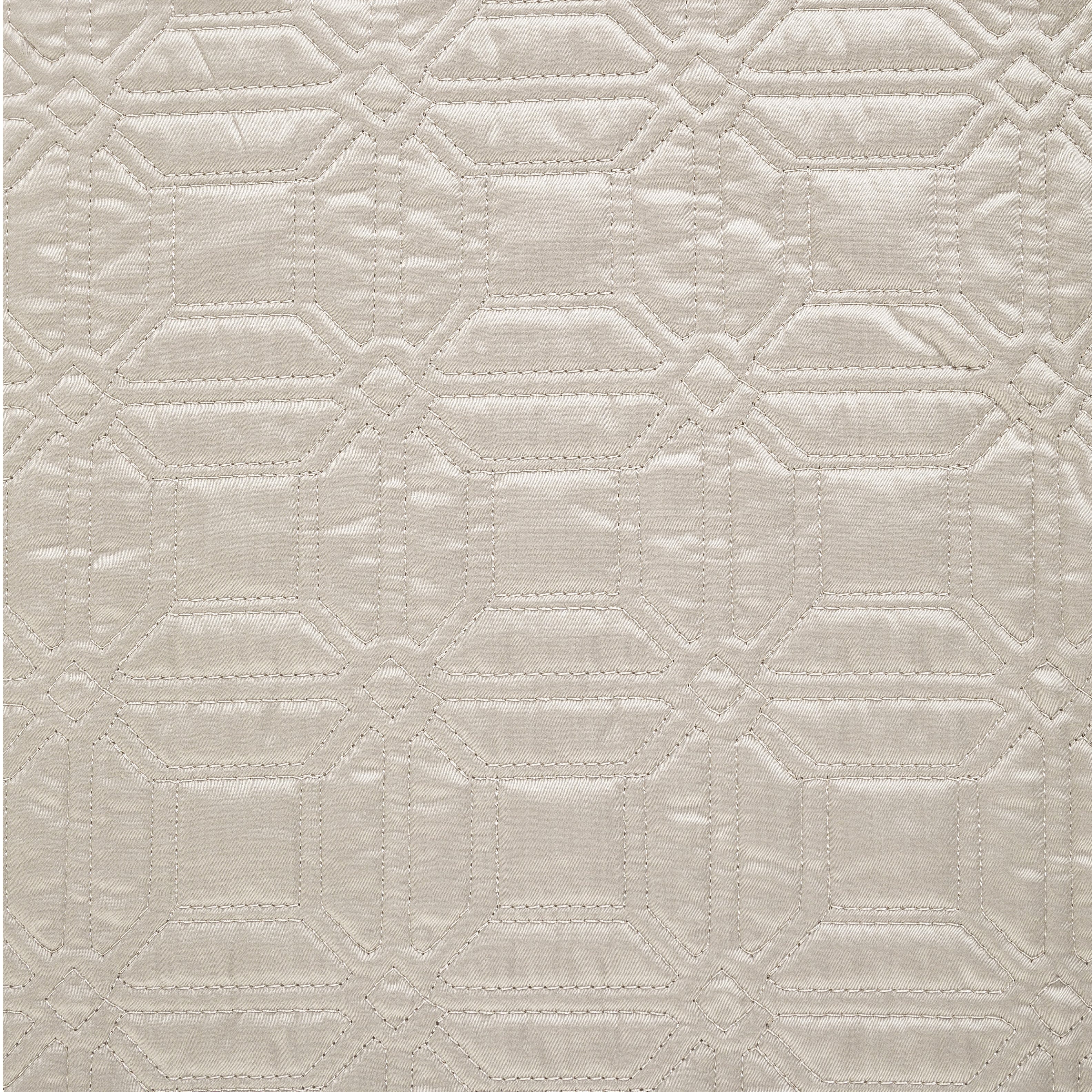 Close-up view of quilted fabric in a cream color featuring geometric stitching with a diamond and square pattern.