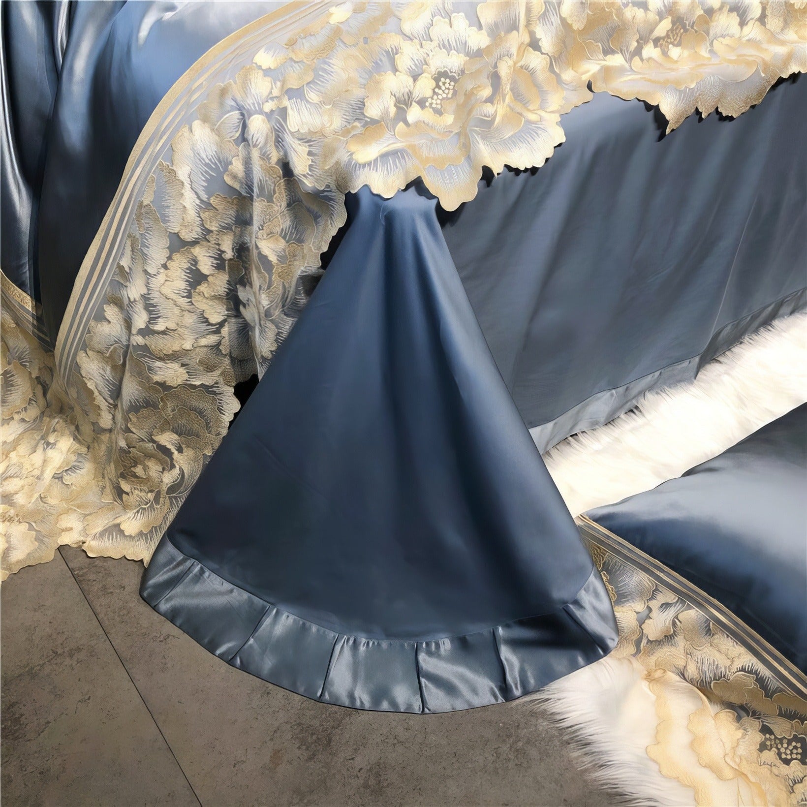 Blue satin bedding draped over the bed edge, showcasing gold floral lace trim and pleated detailing, with a soft white fur rug partially visible below.

