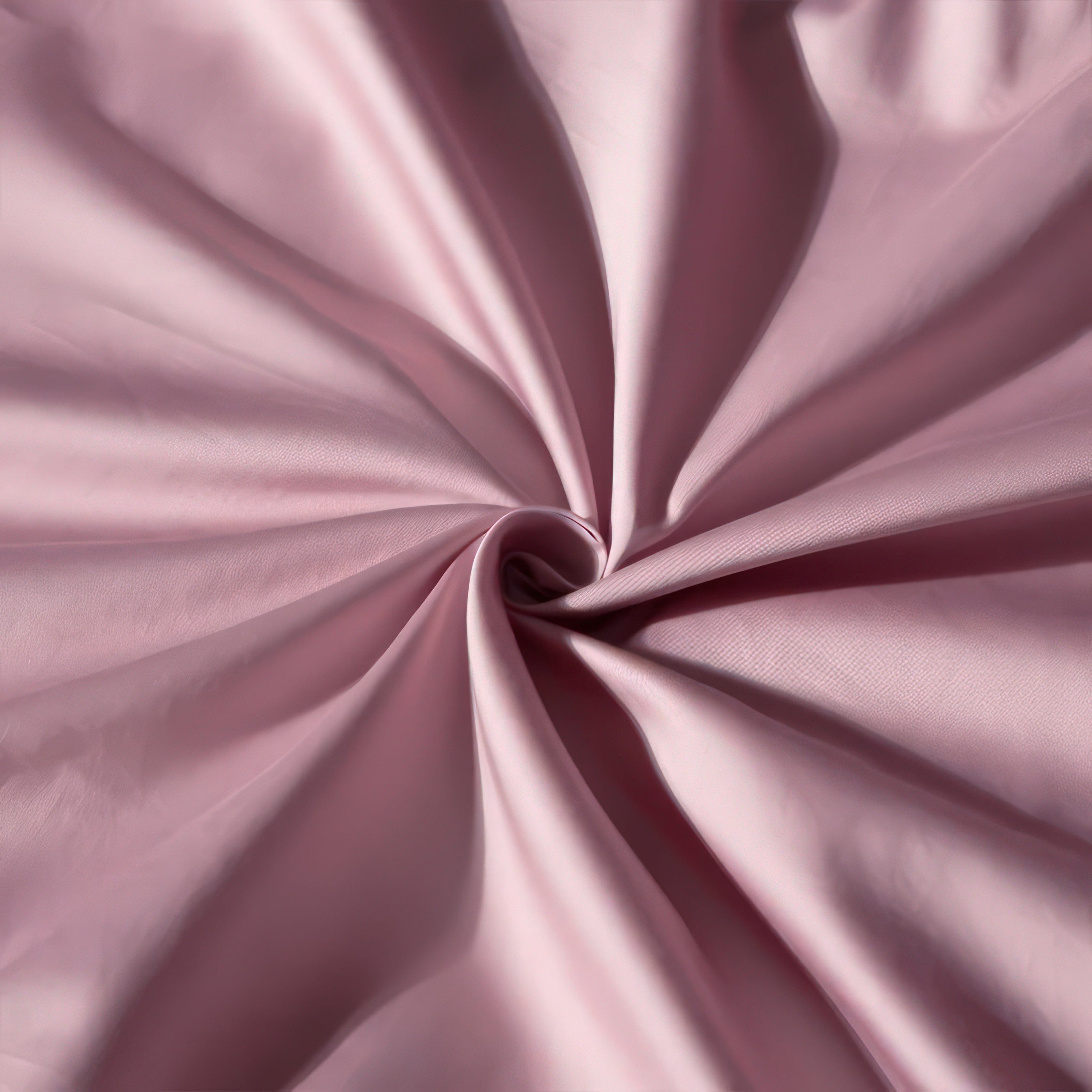 A close-up view of luxurious, soft pink fabric elegantly gathered into a spiral pattern, showcasing its smooth texture, silky sheen, and rich color. Perfectly highlights the premium quality and sophistication of the material.

