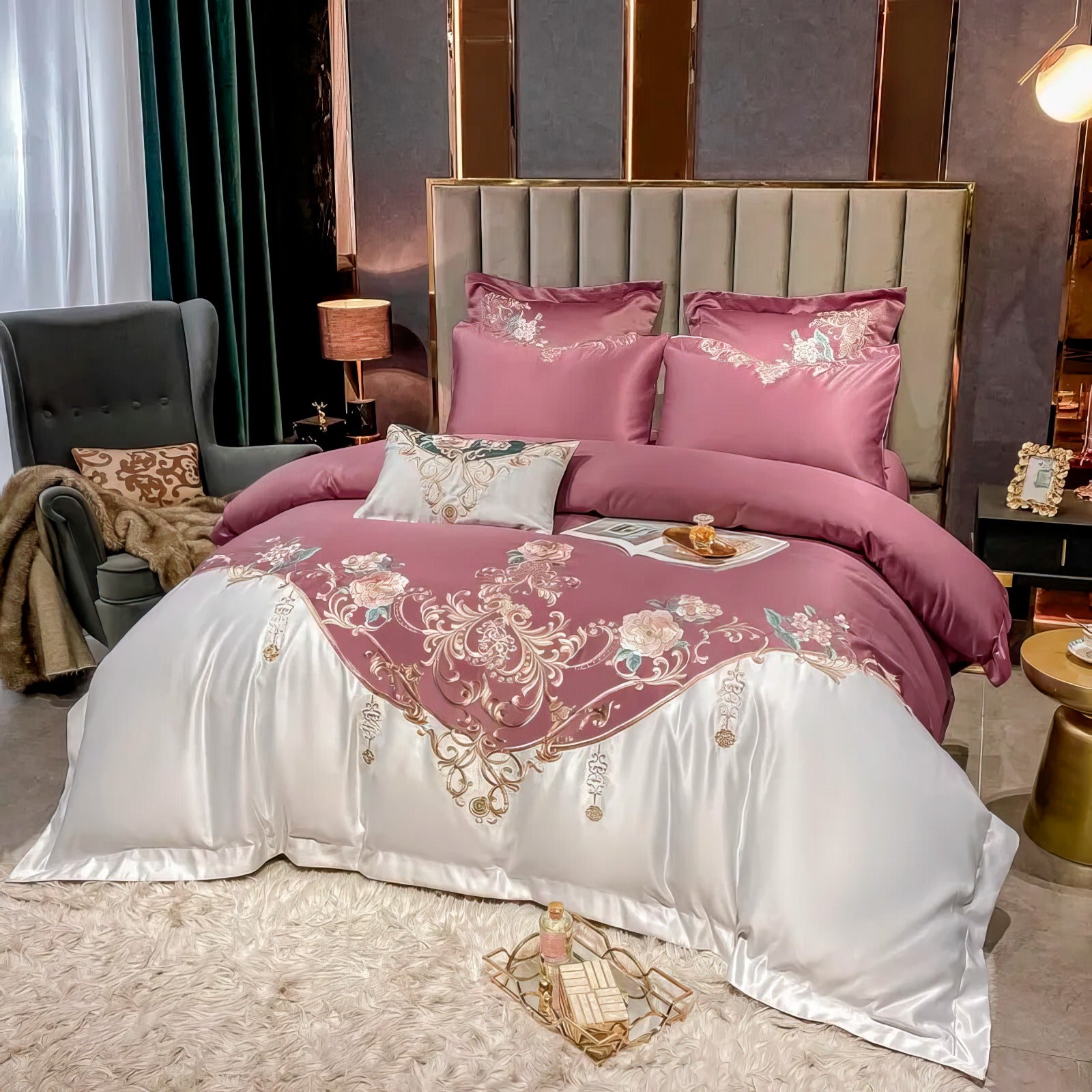 A luxurious bedroom setup showcasing a bedding set with a mauve duvet cover elegantly embroidered with gold floral patterns. The white satin base adds a sleek contrast, complemented by matching pillowcases. A modern tufted headboard frames the bed, flanked by warm lighting and stylish side tables, while a plush white rug and an accent chair enhance the cozy yet opulent ambiance.

