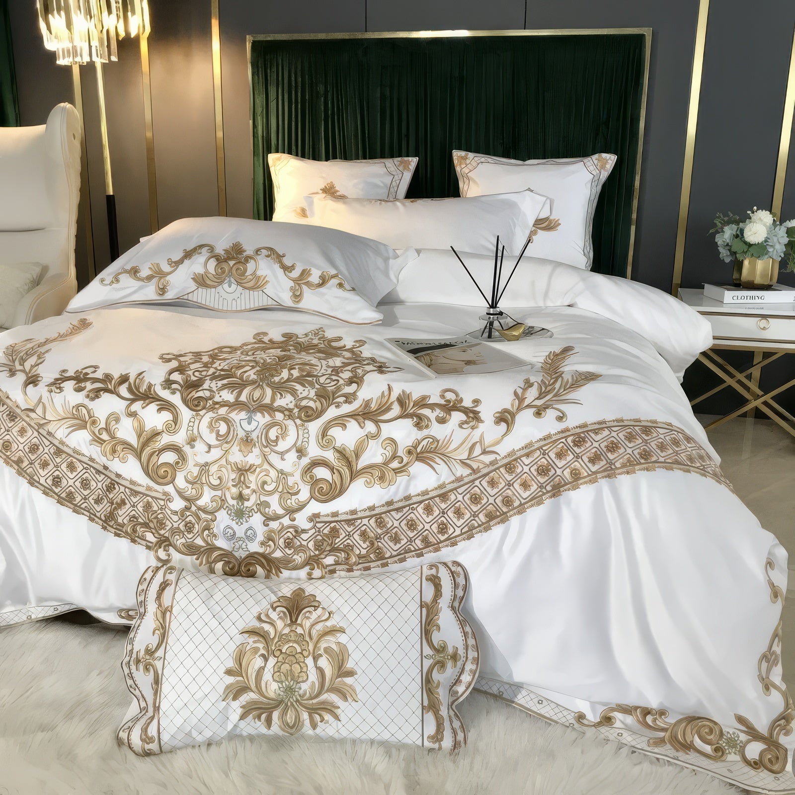 A close-up view of a luxurious white bedding set featuring intricate gold embroidery with baroque-inspired patterns. The set includes matching pillowcases and a bolster pillow with a quilted texture and ornate gold detailing. The bedding exudes sophistication, complemented by a plush green velvet headboard and a white and gold bedside table adorned with decorative items, creating an opulent bedroom atmosphere.

