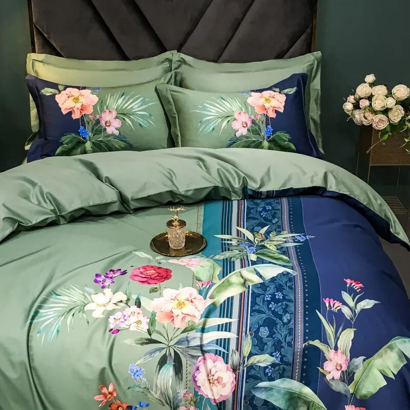 A vibrant bedding set crafted from premium Egyptian cotton, featuring a striking tropical floral design in shades of green and navy blue. The pillowcases highlight lush palm leaves and blooming flowers that harmonize with the intricate patterns on the duvet cover. A gold decorative tray and crystal glass accentuate the luxurious aesthetic, complemented by the black tufted headboard and a bouquet of roses on a side table. The scene exudes elegance and sophistication.

