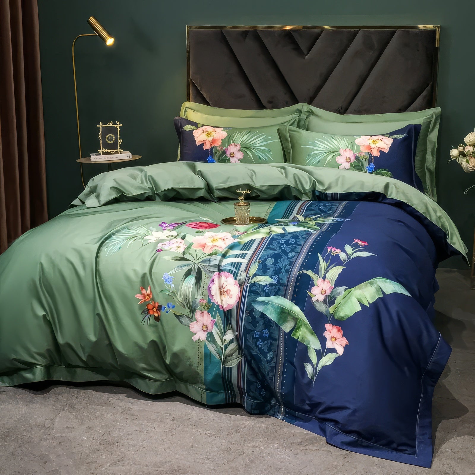 A premium bedding set crafted from 100% Egyptian cotton, offering unparalleled softness and durability. The design features vibrant tropical flowers and lush green foliage on a dual-tone green and navy blue duvet cover, paired with coordinating pillowcases that complement the tropical theme. Set against a dark green wall, the arrangement includes a sophisticated black tufted headboard, a gold nightstand adorned with minimalistic decor, and a vase of white roses for an elegant touch.

