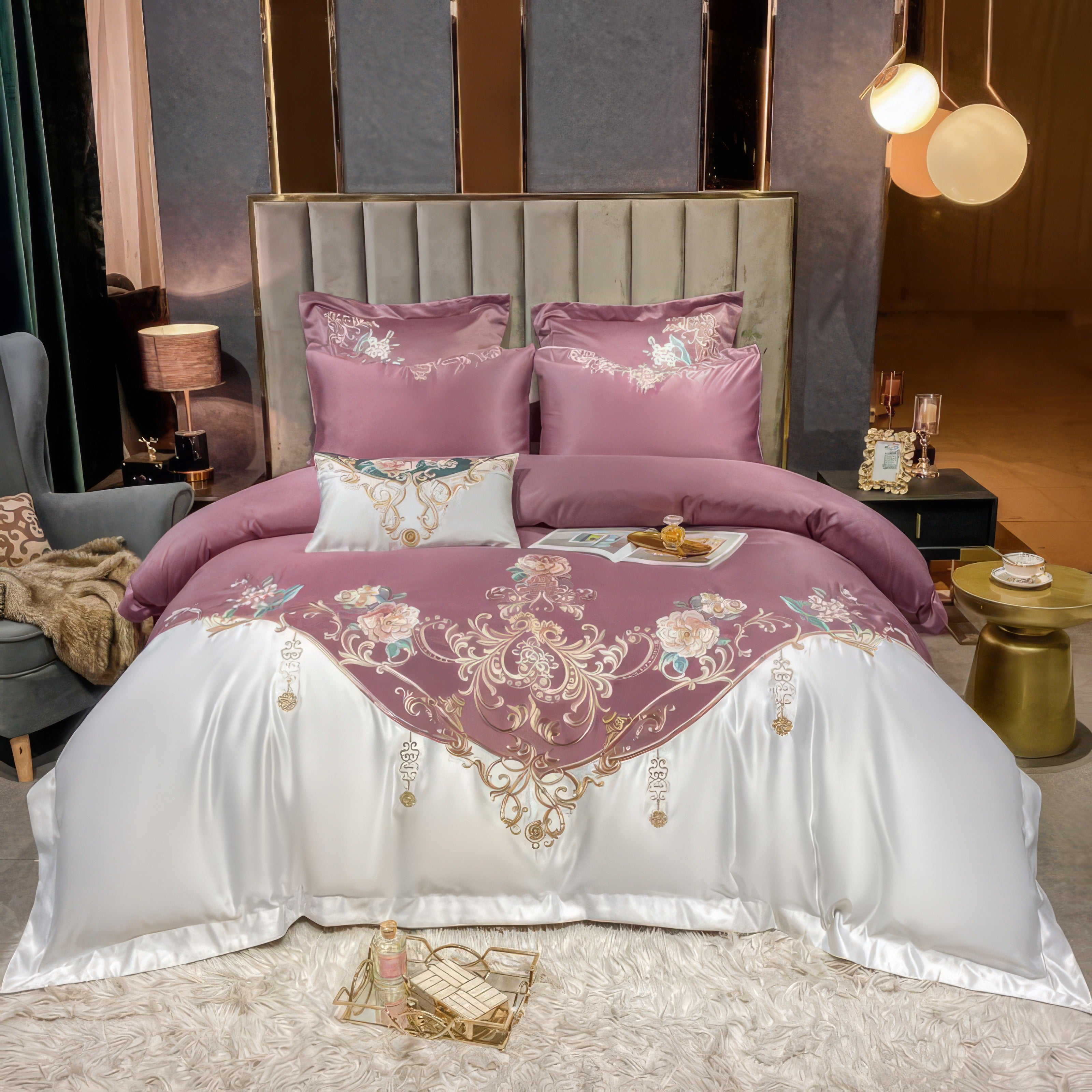 A luxurious bedding set featuring a rich mauve duvet cover adorned with delicate gold embroidery and floral accents. The white satin base adds a touch of elegance, while matching pillowcases complement the ensemble. The setup includes a tufted gray headboard, soft ambient lighting, and modern side tables, creating a warm and sophisticated bedroom aesthetic.

