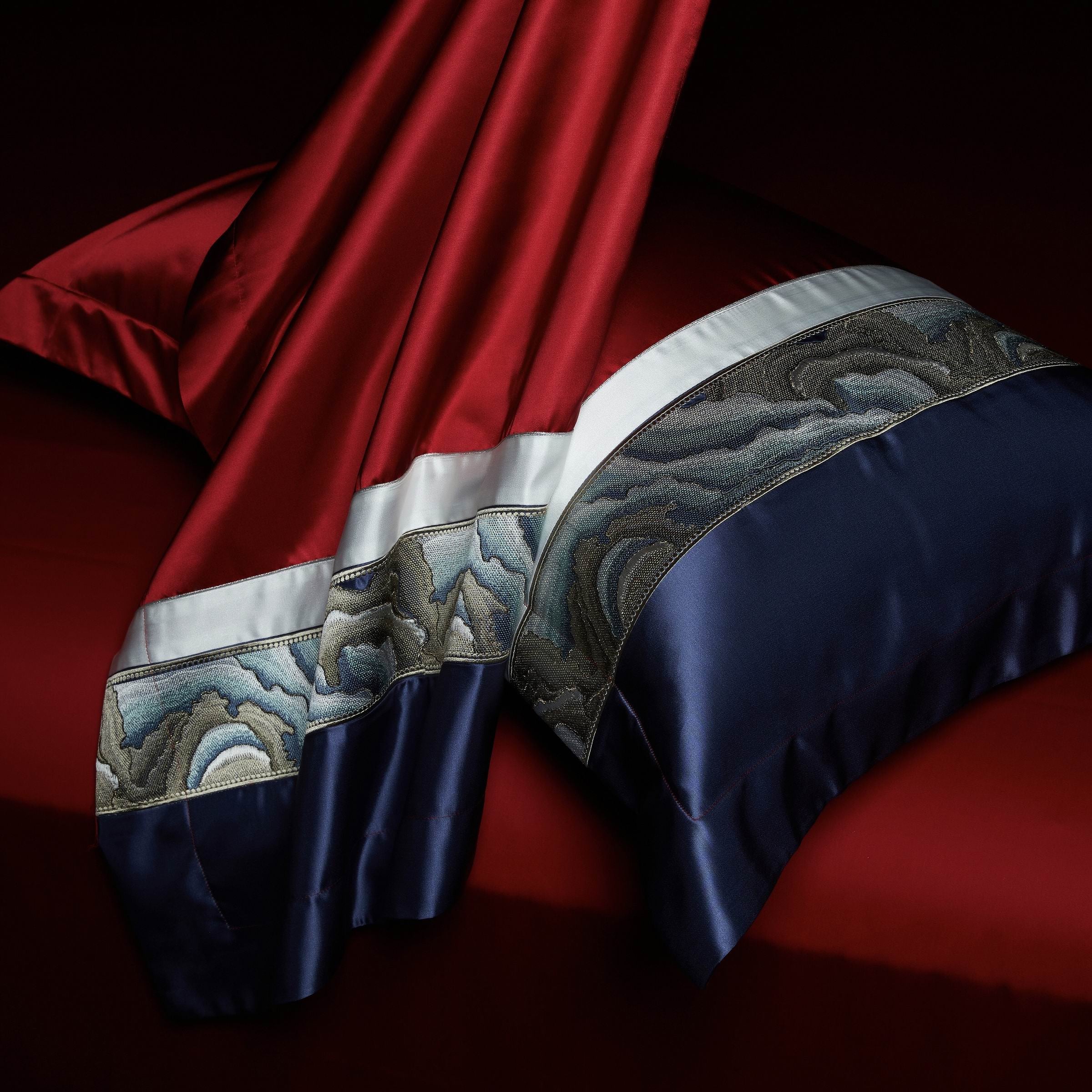 This close-up shot emphasizes the exquisite contrast between the burgundy and navy hues, with intricate marble-patterned trims adding a refined touch. The luxurious satin sheen enhances the fabric's depth, while the draped design showcases the bedding's premium craftsmanship. Ideal for those seeking opulent style combined with modern elegance in their bedroom decor.