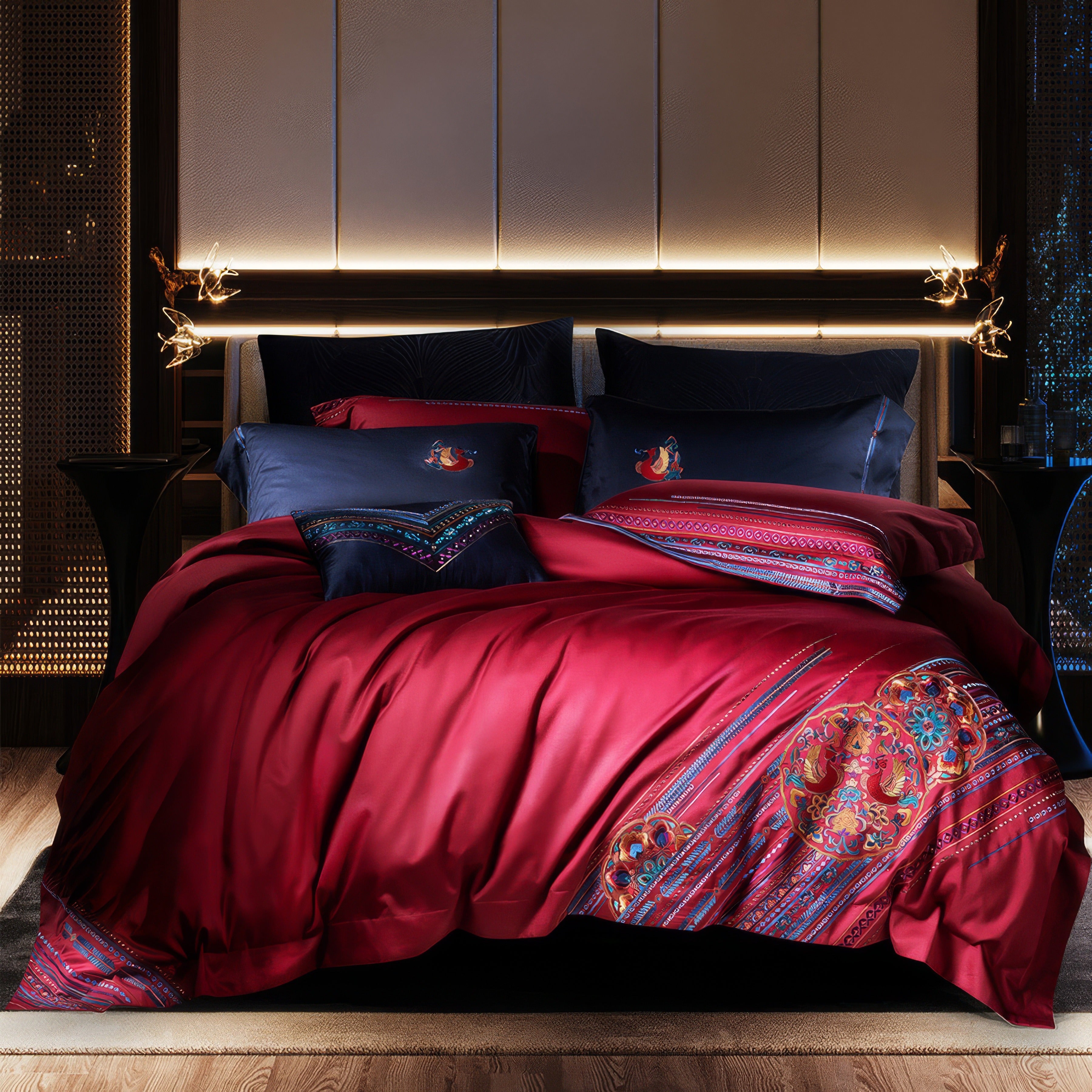 Luxurious bedding set made of Egyptian cotton featuring a deep red duvet with intricate multicolored embroidery and traditional patterns. Coordinating navy blue pillowcases showcase elegant embroidered motifs, adding contrast and sophistication to the rich, dark-toned bedroom setting.

