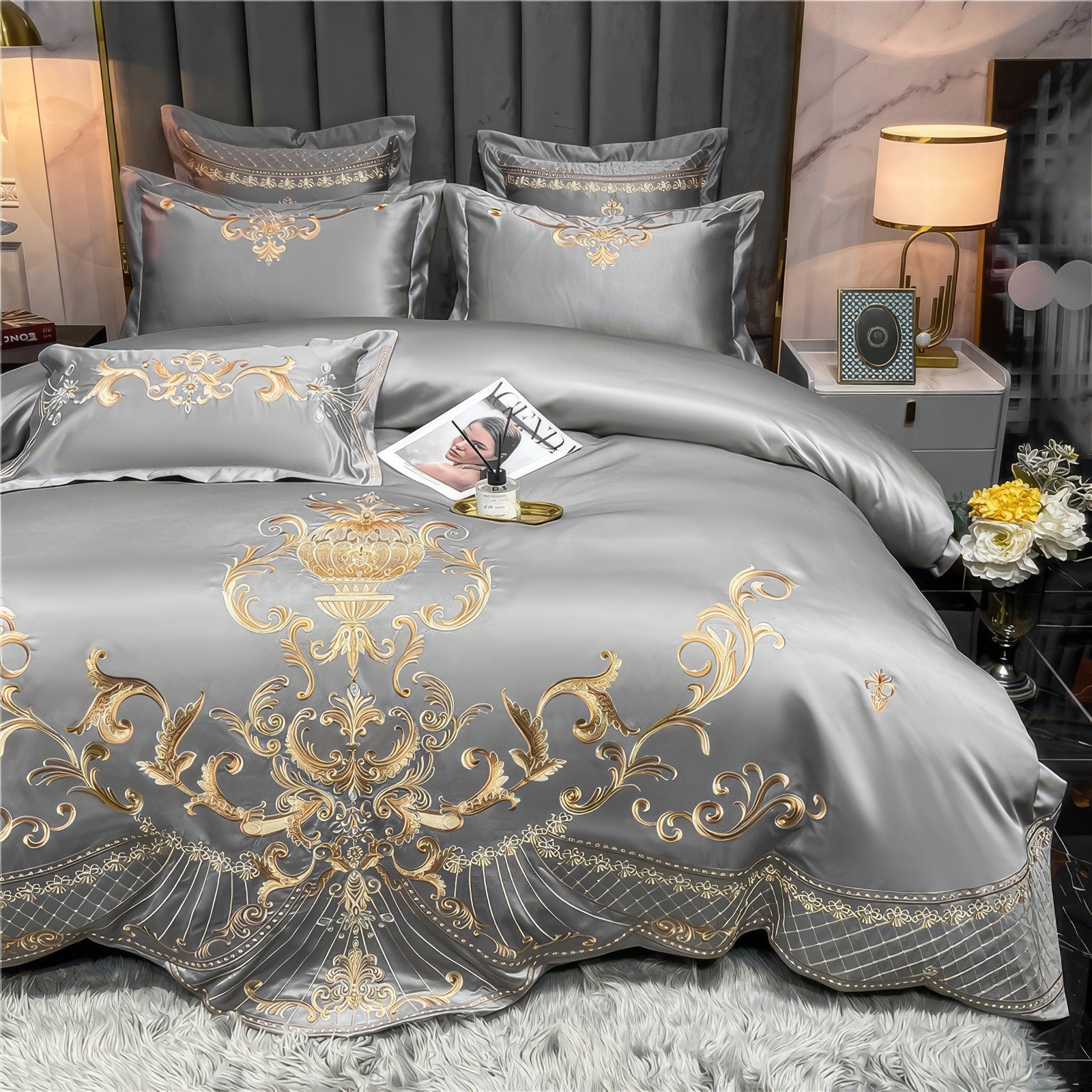 Grey Egyptian cotton bedding set with gold embroidery, featuring intricate baroque patterns across the duvet cover and matching pillowcases. The set has a smooth, silky finish and drapes elegantly over the bed.

