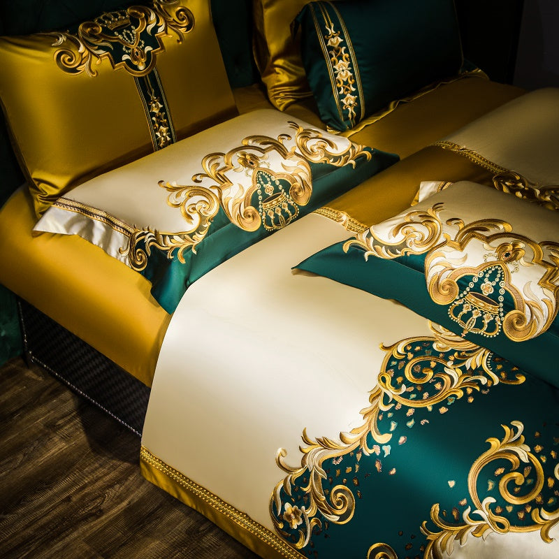 Luxurious bedding set with intricate baroque-style embroidery in gold and emerald green tones. Features matching pillowcases and a duvet cover showcasing ornate patterns, designed to elevate the elegance of any bedroom.