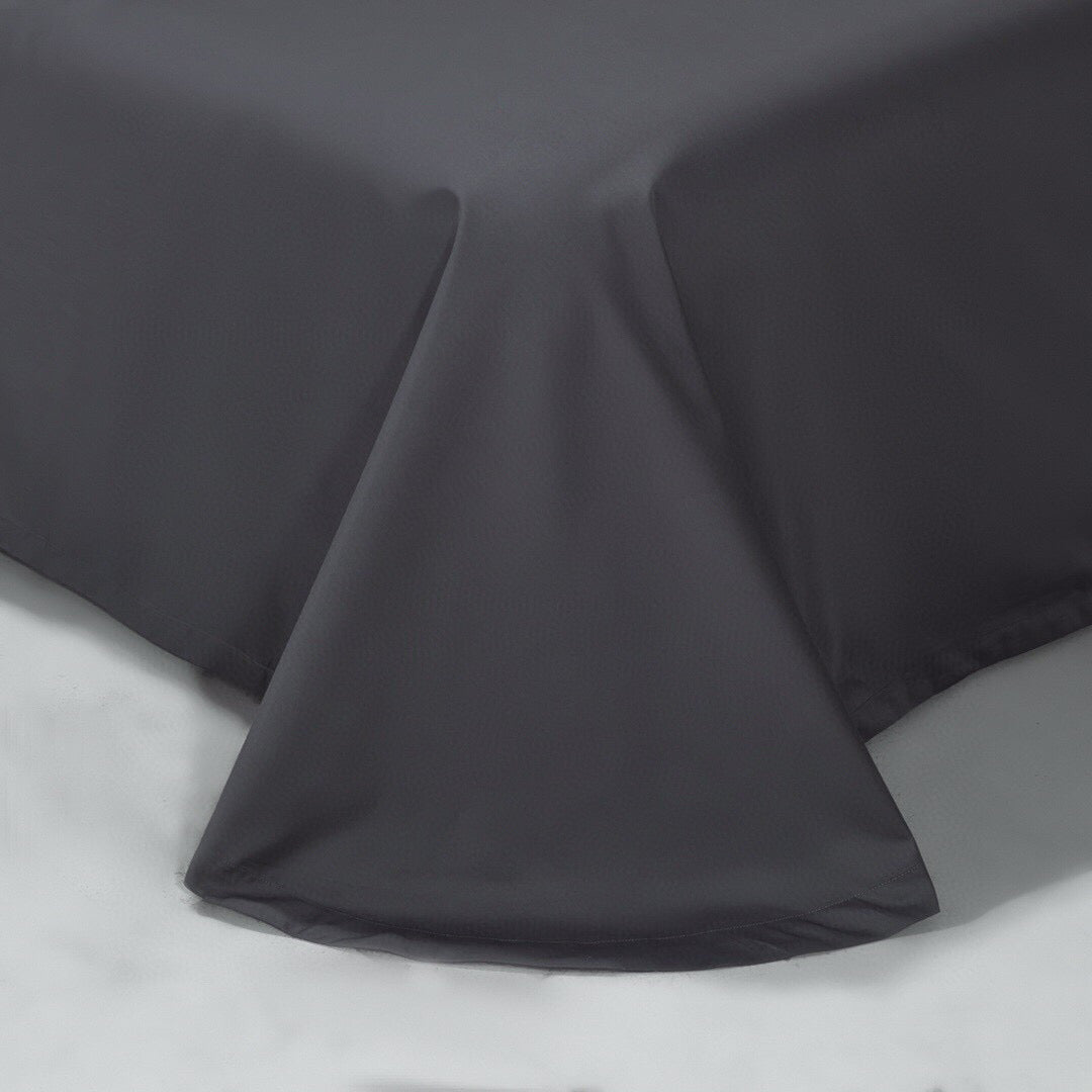 Charcoal gray bed sheet with a smooth, flowing drape reaching the floor, highlighting a minimalist and elegant design.

