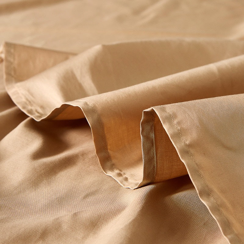 Golden beige fabric with soft folds and stitched edges, showcasing a smooth texture and elegant drape.

