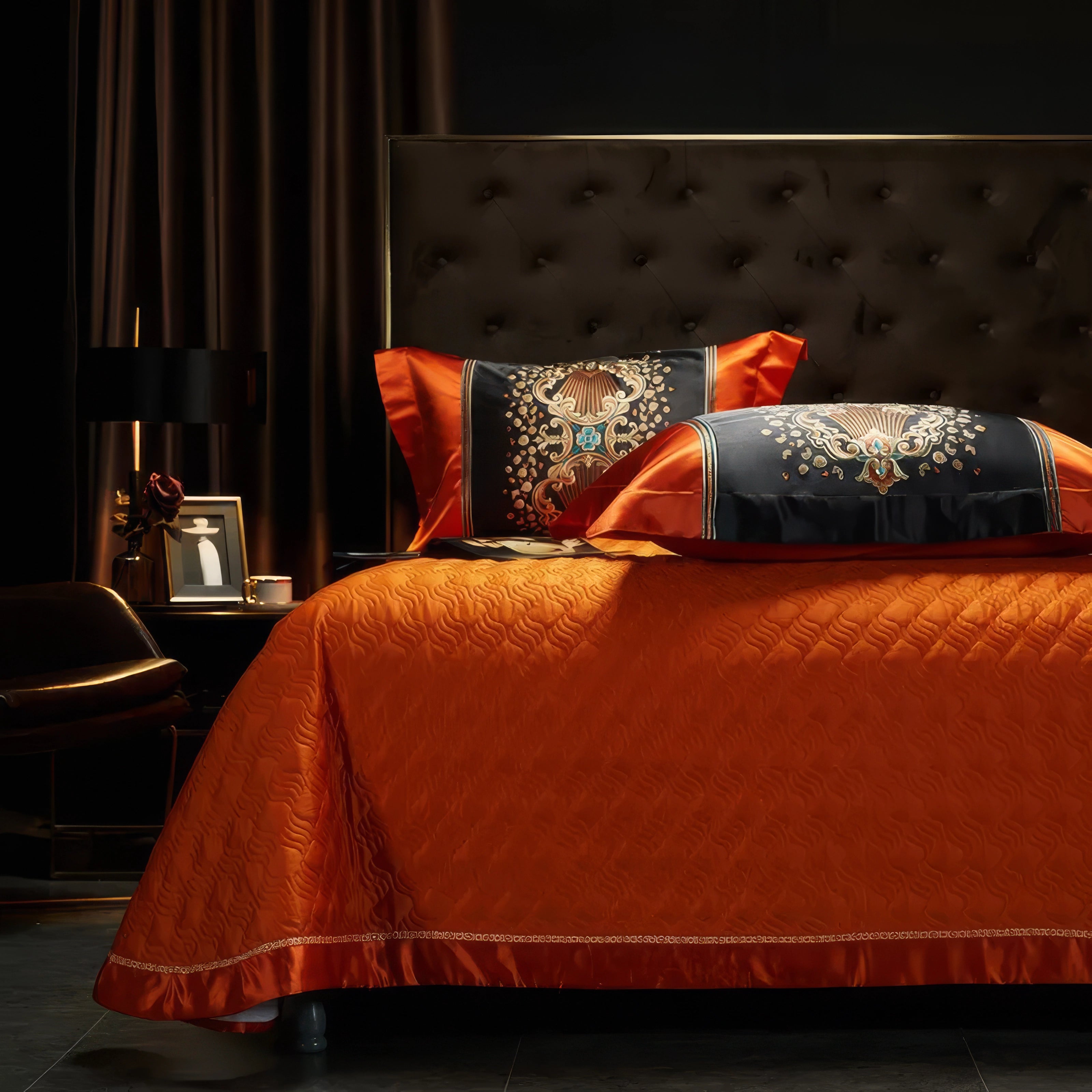 Elegant orange bedding set with a textured quilted design, paired with black pillowcases featuring ornate gold and turquoise embroidery, styled in a luxurious bedroom with a tufted headboard and ambient lighting.