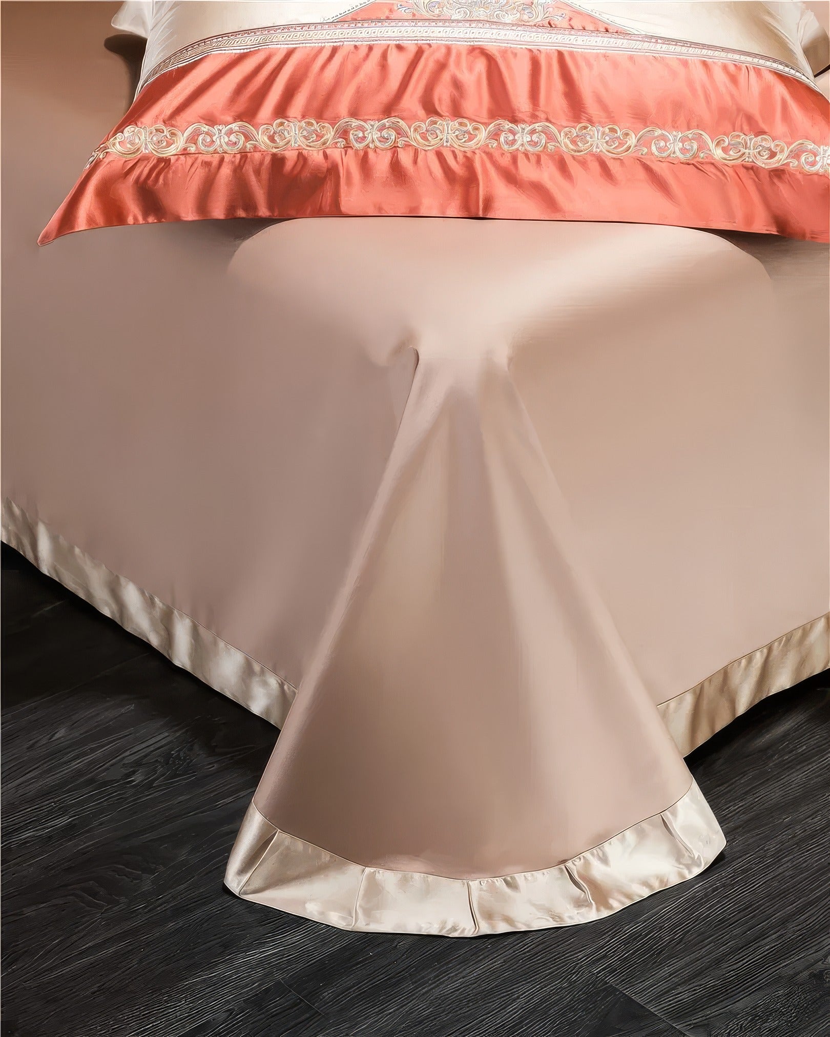 Full view of a champagne-colored bed skirt draping elegantly over the edge of a bed, complemented by a satin pillowcase with intricate coral embroidery and a shimmering finish. The bed skirt’s smooth texture adds a touch of sophistication to the bedroom decor.

