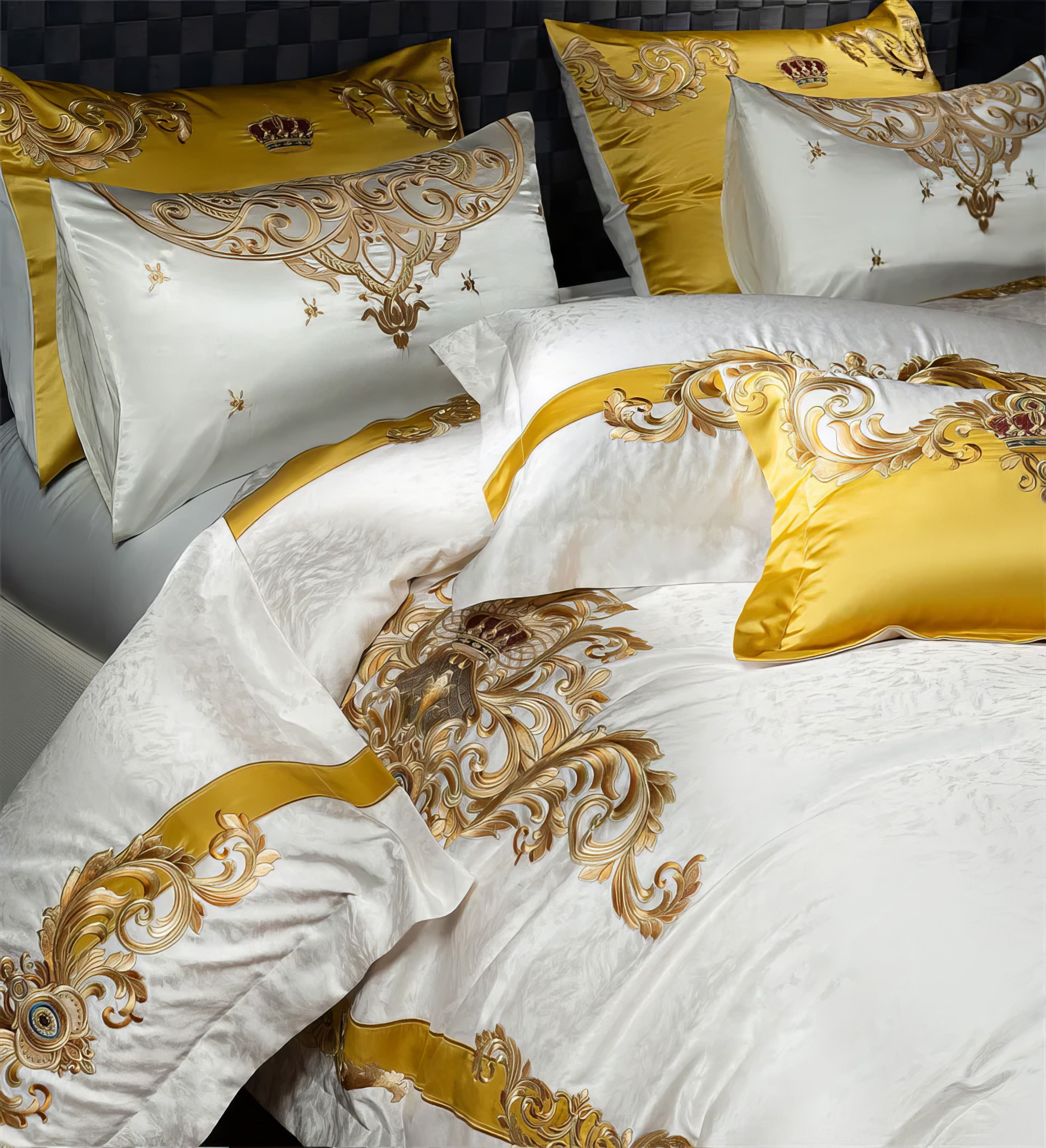 A sumptuous bedding set in pristine white adorned with rich golden embroidery and accents. The pillowcases showcase elaborate regal patterns with crowns and filigree, complementing the matching duvet cover embellished with opulent baroque-inspired swirls and ribbons. The golden decorative elements stand out vividly, creating an air of luxury and grandeur suitable for a royal-inspired bedroom décor.