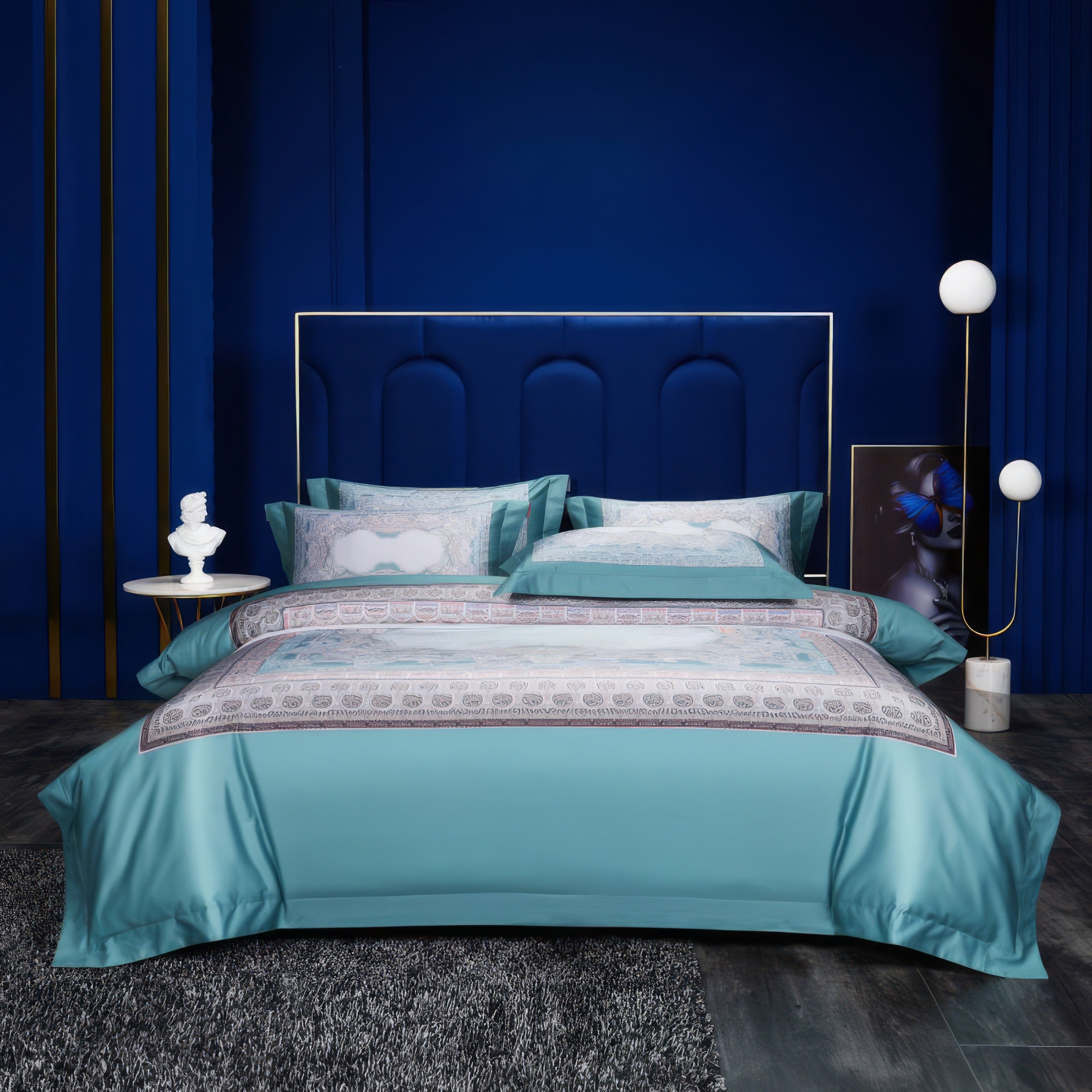 Luxurious turquoise bedding set with ornate patterned detailing in soft hues of white and silver, complemented by a dark blue upholstered headboard and contemporary decor in a modern bedroom setting.

