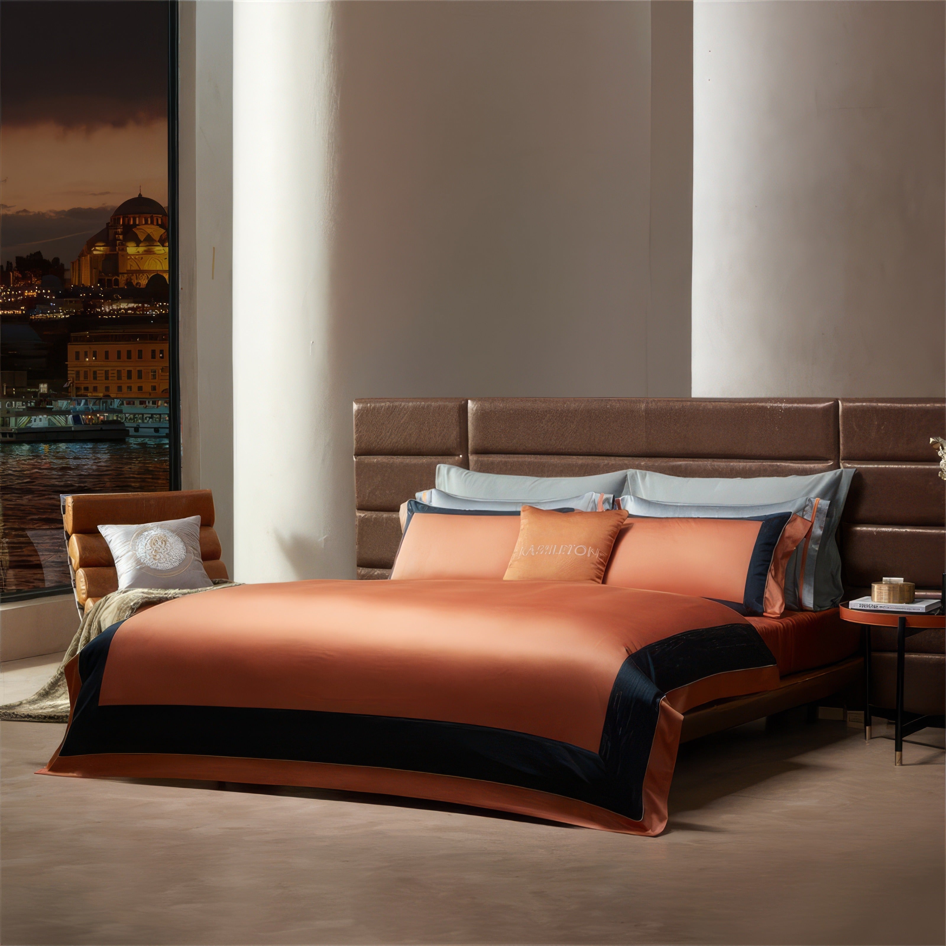 Vibrant orange bedding with sleek black accents and matching pillowcases, set against a modern upholstered headboard. The room exudes warmth and sophistication, with a cozy ambiance enhanced by a cityscape view through the window. Light blue pillows contrast subtly with the orange tones, completing the elegant aesthetic.

