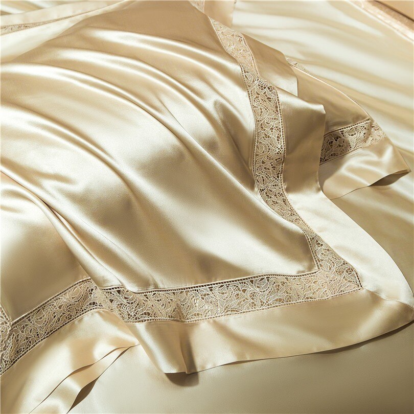 A detailed close-up of cream-colored silk bedding, highlighting the smooth, lustrous texture of the fabric and its elegant lace trim along the edges. The luxurious material flows gracefully, emphasizing its soft and high-quality craftsmanship.