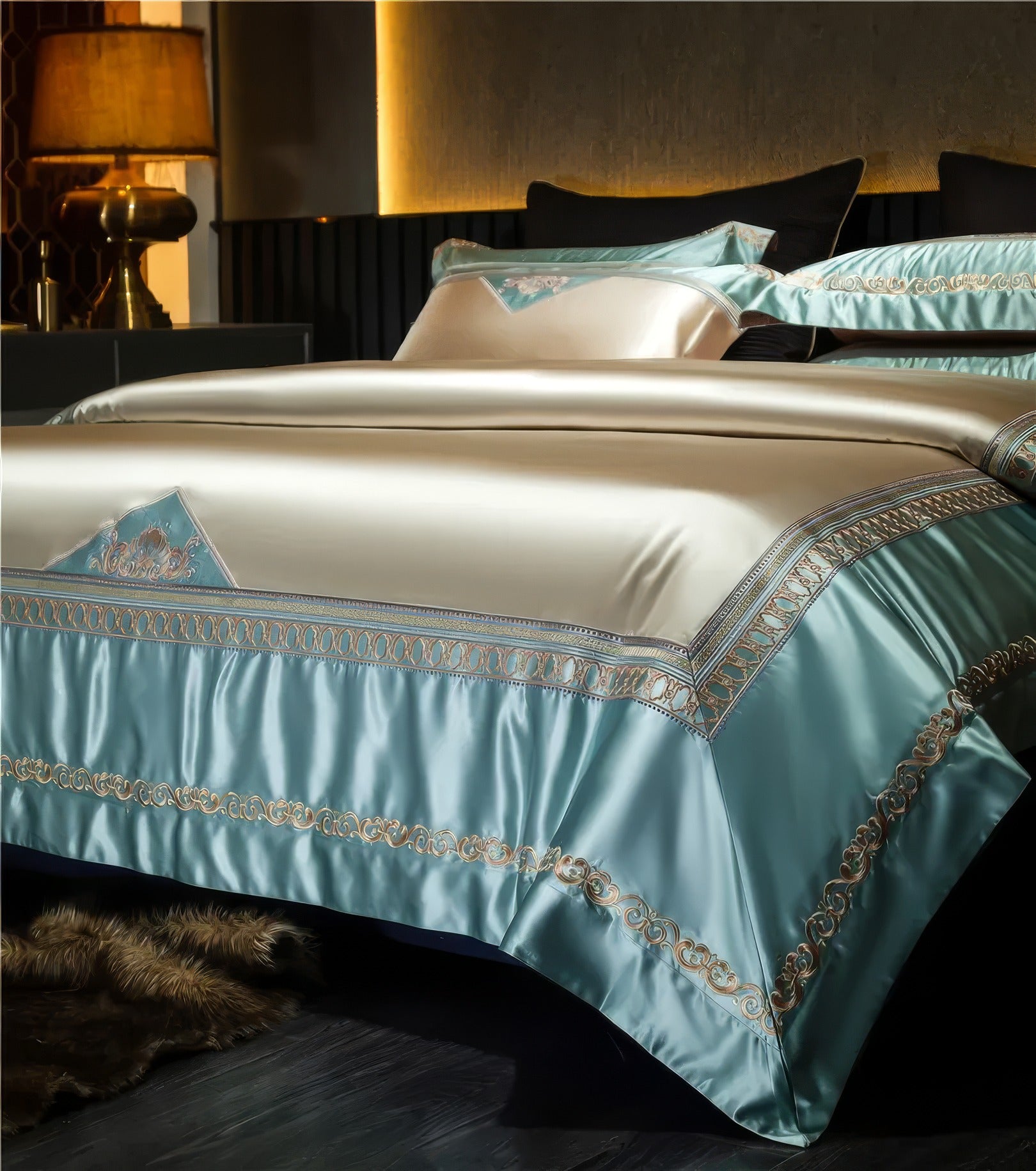 Elegant satin bedding set in blue and beige tones, featuring intricate gold embroidery, displayed in a modern bedroom with warm lighting and a dark, sophisticated interior.

