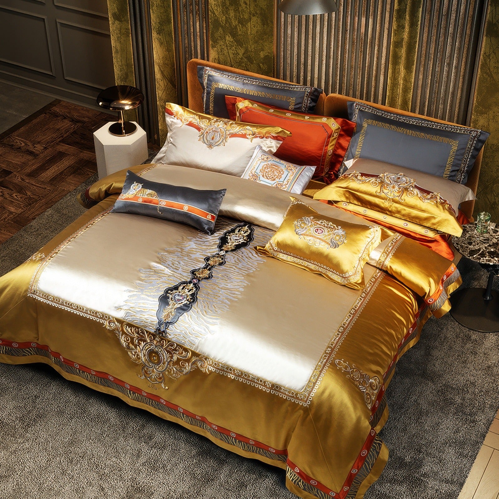 Opulent bedding ensemble featuring gold satin fabric with intricate embroidery, accented by vibrant orange and grey pillows, styled on a plush upholstered bed in a richly decorated room with textured walls and luxurious furnishings.

