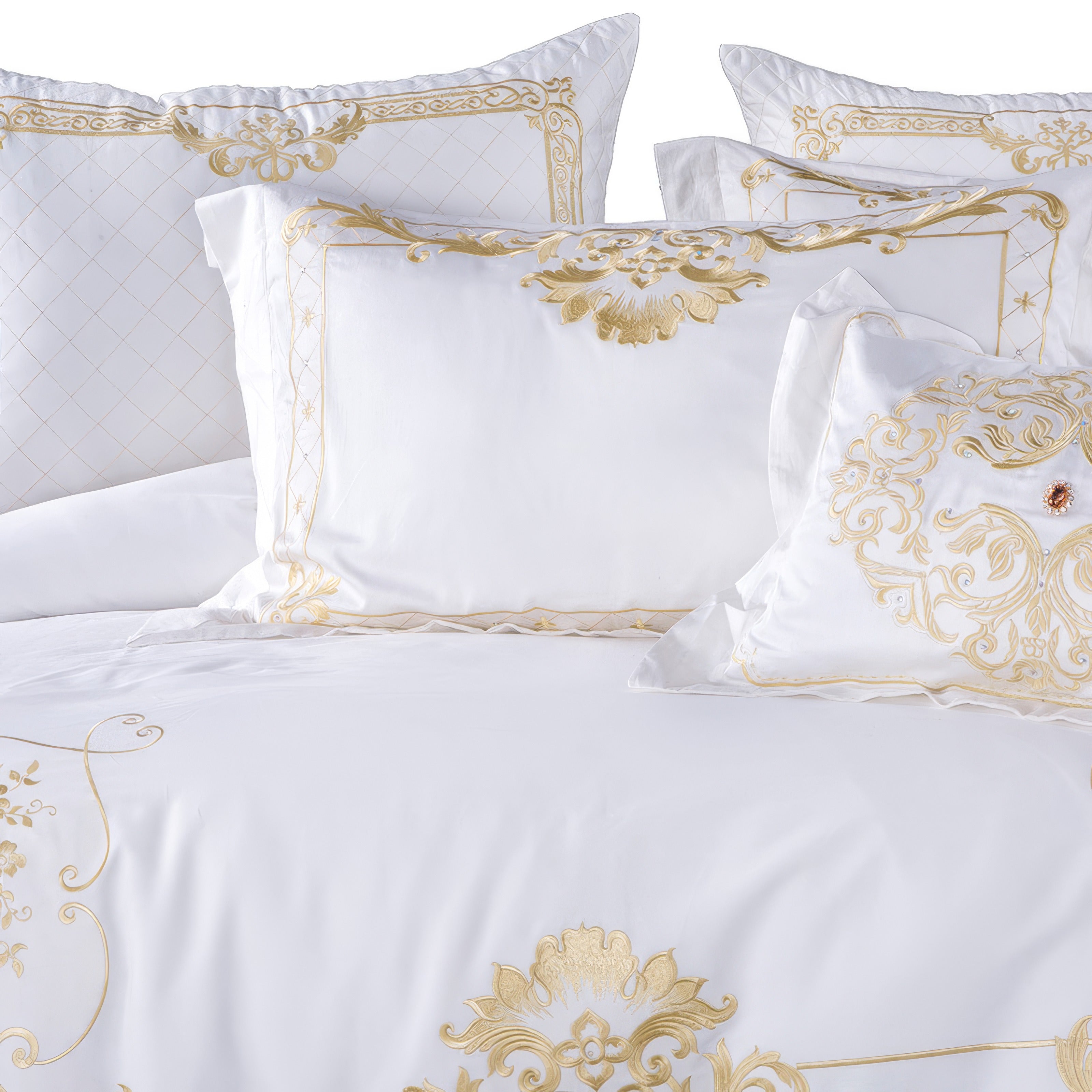 A luxurious white bedding ensemble highlighted by intricate golden embroidery on the pillows and duvet cover. The design features elegant floral and scroll motifs, a diamond-quilted pattern, and regal accents. A jeweled centerpiece on one pillow adds a touch of opulence to the overall sophisticated aesthetic.