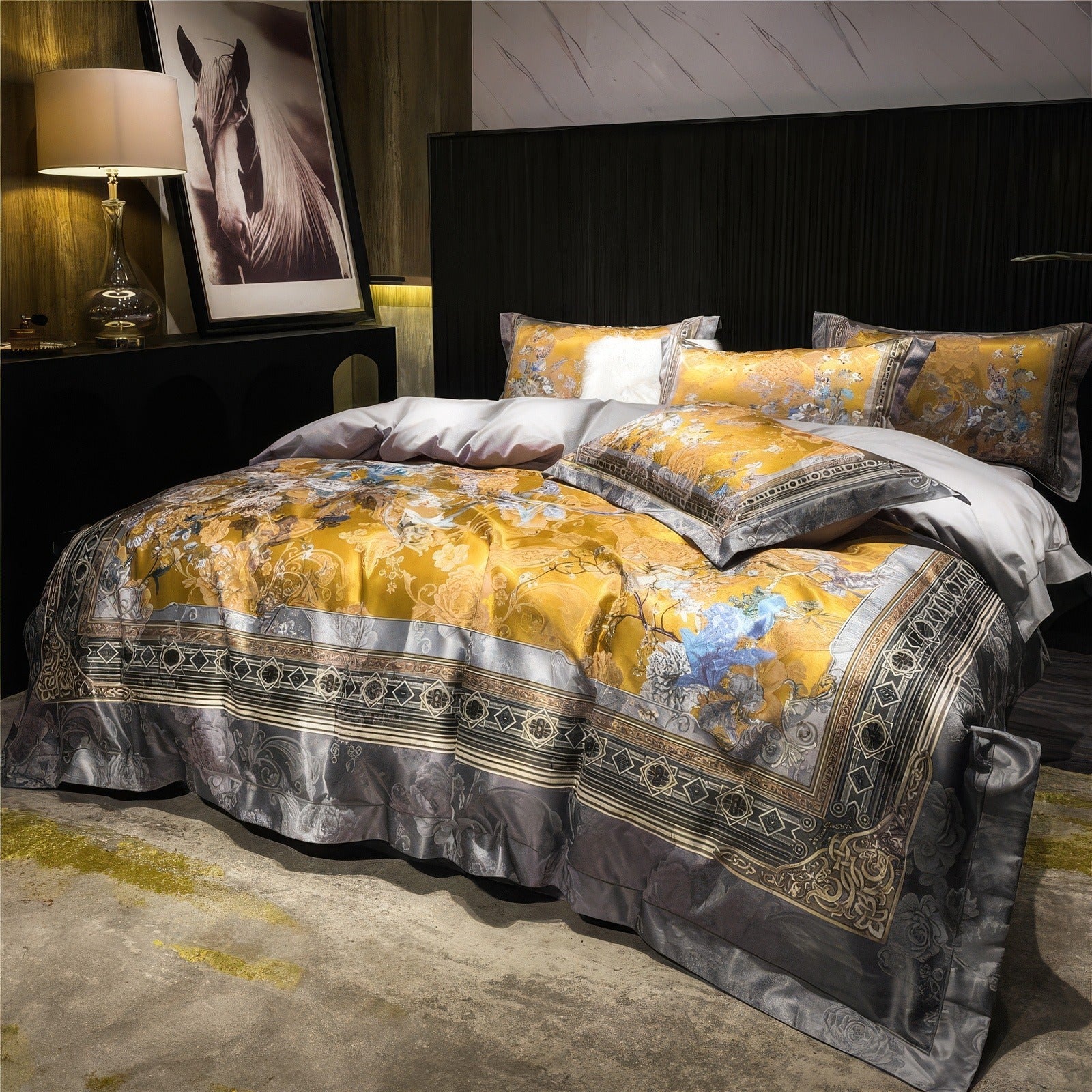 Elegant bedding set with intricate golden floral designs and blue accents, paired with gray detailing, draped across a luxurious bed with matching pillowcases and decorative pillows in a modern bedroom setting.

